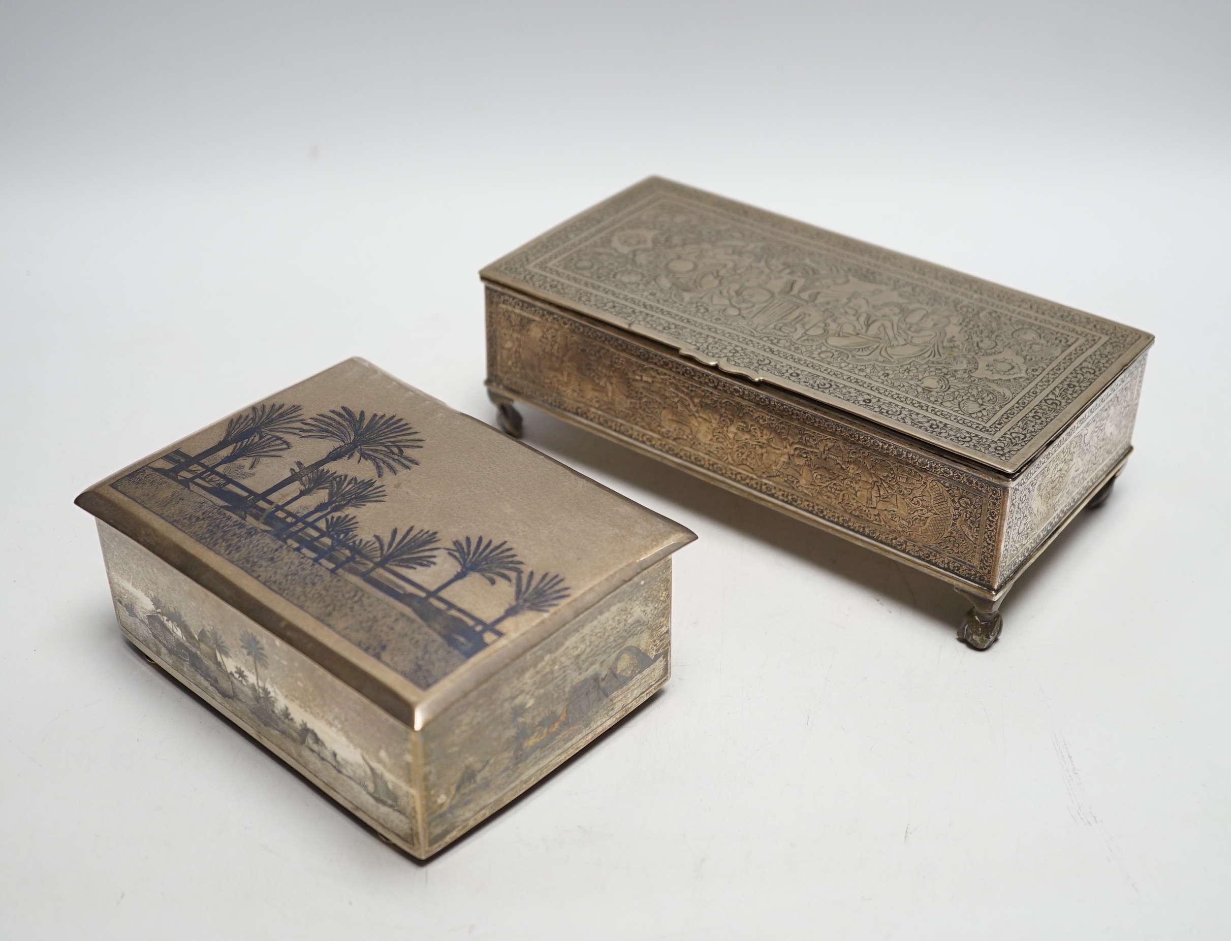 A Persian engraved white metal rectangular cigarette box and a similar white metal and niello cigarette box, largest 20.3cm.